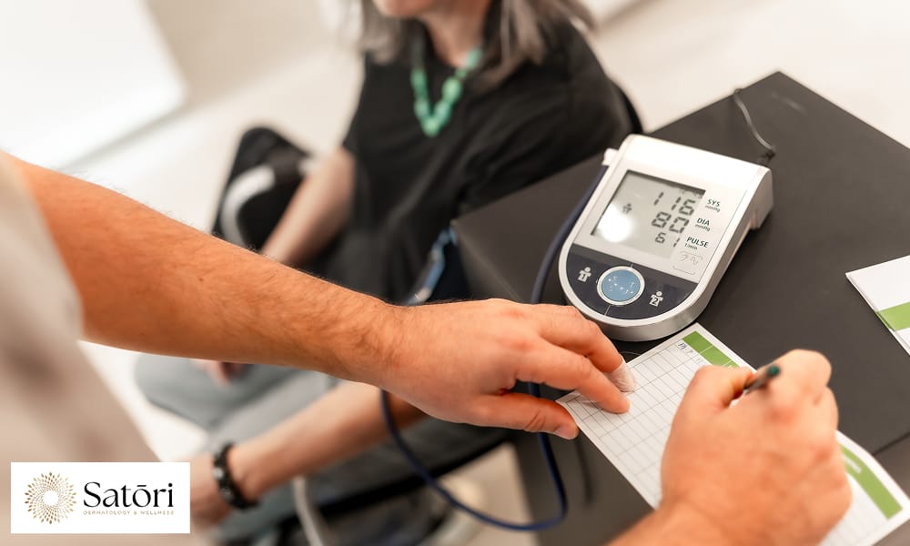 Doctor writing the measures of female blood pressure