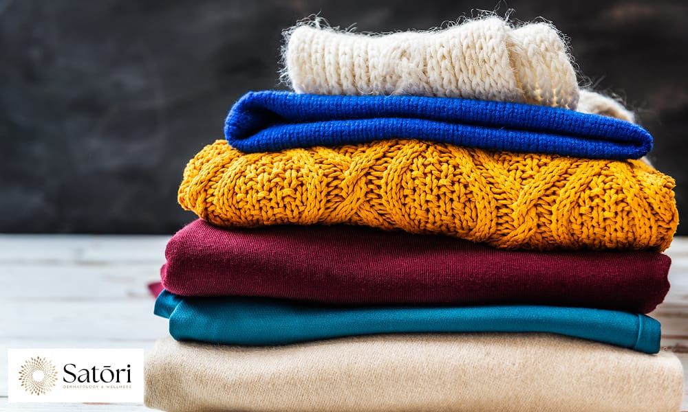 Stack of sweaters showing clothing choices that can increase sweating.