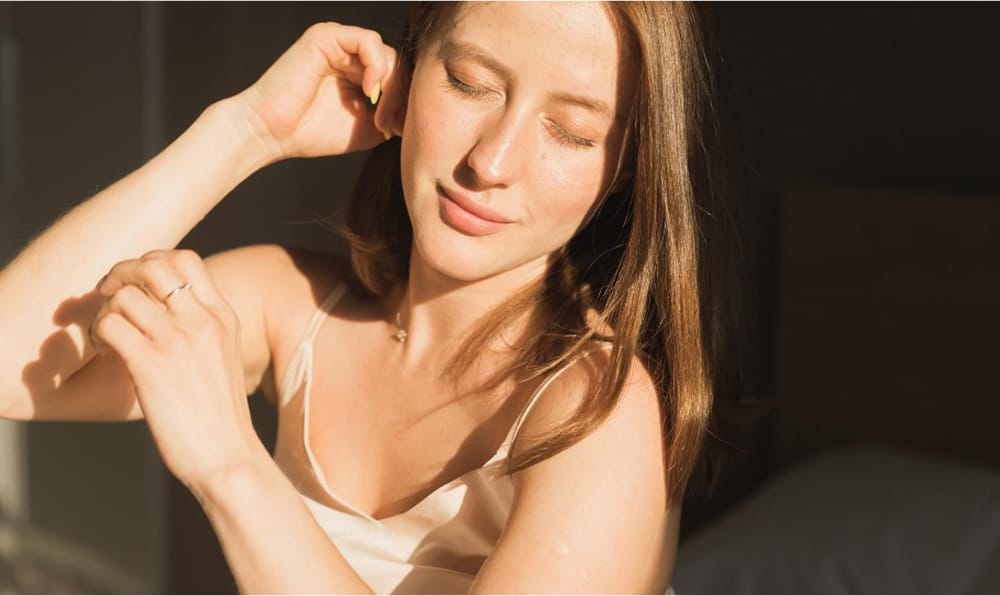 Woman standing by a window with sunlight shining on her face